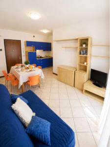 a living room with a blue couch and a table at Residence Pineta - Agenzia Cocal in Caorle