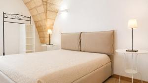 a bedroom with a white bed with two lamps at Corte Nizza in Taviano