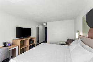 a hotel room with a bed and a flat screen tv at Spark by Hilton in Beckley +14 photos