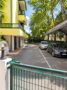 two cars parked in a parking lot next to a building at Residence Pineta - Agenzia Cocal in Caorle