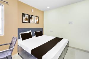 a bedroom with a bed and a table and chairs at Hotel O HOLIDAY STAR IN in Hyderabad +18 photos