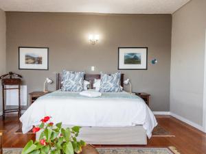 a bedroom with a large bed with blue and white pillows at Harewood Lodge in East London