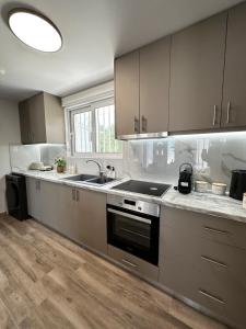 a kitchen with a sink and a stove top oven at Oleana Grand Appartment in Lampi