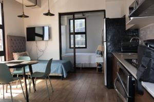 a kitchen with a table and a room with a bed at EON Two Bedroom Apartment 1303 in Estación Pamplona