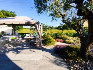 a garden with a gazebo and a table and chairs at La Papessa in Savio di Ravenna