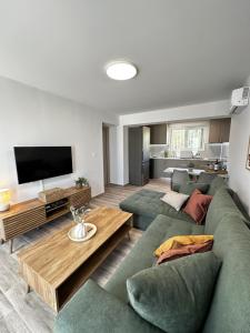 a living room with a green couch and a television at Oleana Grand Appartment in Lampi