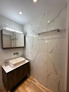 a bathroom with a sink and a mirror at Oleana Grand Appartment in Lampi +19 photos