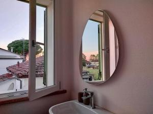 a bathroom with two mirrors and a sink and a window at La Papessa in Savio di Ravenna