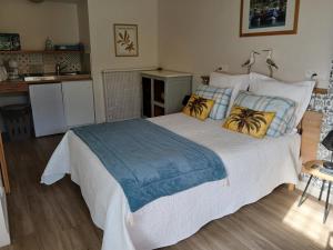 a bedroom with a large bed and a kitchen at Voiles et Terrasses by Corinne Résidence face au port in Le Tréport
