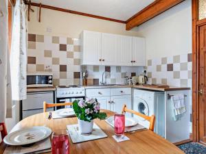 a kitchen with a wooden table with flowers on it at 2 Bed in Spalding oc-83540 in Donington