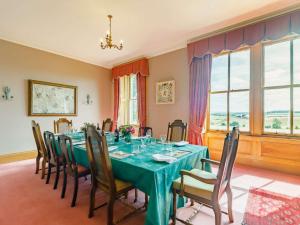 a dining room with a green table and chairs at 5 Bed in Melrose oc-89348 in Newtown Saint Boswells