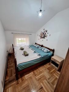 a bedroom with a bed with a wooden floor at Elena Apartment in Plužine