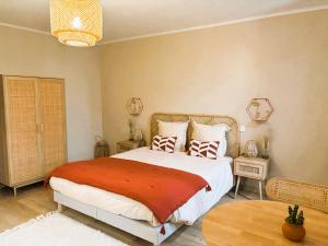 a bedroom with a large bed and a table at Le cottage du Breil in Verfeil