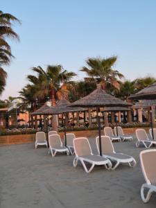 a row of chairs and umbrellas on a beach at Valamar ED Apartment in Hamallë