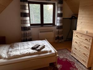 a bedroom with a bed and a window and a dresser at Chata pod Kriváňom in Východná