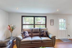 a leather couch in a living room with a window at Lazy Daze in Wasaga Beach in Wasaga Beach