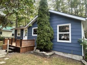 a blue house with a bench in front of it at Lazy Daze in Wasaga Beach in Wasaga Beach