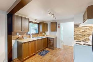 a kitchen with wooden cabinets and a brick wall at Lazy Daze in Wasaga Beach in Wasaga Beach +7 photos