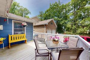 a deck with a table and chairs and a blue house at Wavy Daze in Wasaga Beach in Wasaga Beach