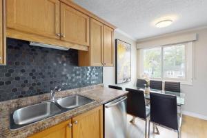 a kitchen with a sink and a table with chairs at Beachy Daze in Wasaga Beach in Wasaga Beach
