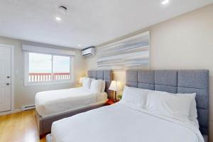 a bedroom with two beds and a large window at Beachy Daze in Wasaga Beach in Wasaga Beach