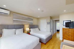 a bedroom with two beds and a flat screen tv at Beachy Daze in Wasaga Beach in Wasaga Beach +19 photos
