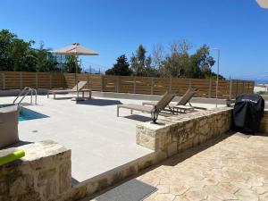 a patio with lounge chairs and a swimming pool at Casa Di Aspa-Serene Escape with Pool near town in Rethymno
