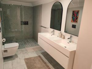 a bathroom with two sinks and a shower and a toilet at Mtunzini South Cottage in Mtunzini +14 photos