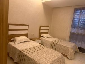 a room with two beds and a window at tanger in Oulad Akkou