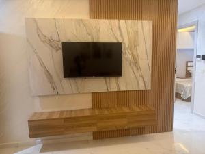 a living room with a television on a wall at tanger in Oulad Akkou