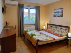 a bedroom with a bed and a desk and a window at Apartments Orange in Uherské Hradiště