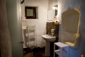 a bathroom with a sink and a toilet and a mirror at Cob Village - Casute din lut, self check-in, experienta in natura in Berca