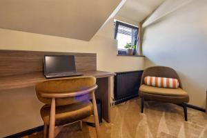a room with a desk with a laptop and two chairs at Motel Reich in Velenje
