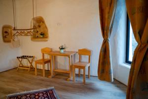 a small table and chairs in a room with a window at Cob Village - Casute din lut, self check-in, experienta in natura in Berca