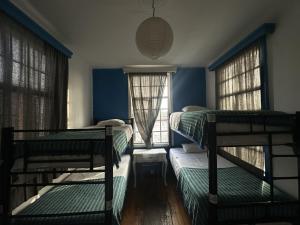 a room with three bunk beds and two windows at Massiosare El Hostal in Mexico City +26 photos