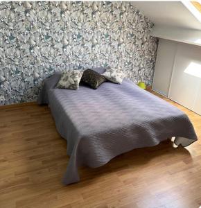 a bed with two pillows on it in a bedroom at Le petit cocon in Brêmes