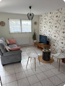 a living room with a couch and a table at Le petit cocon in Brêmes