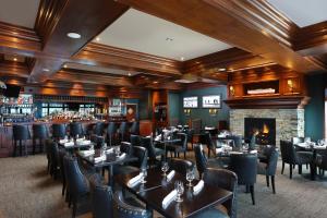a restaurant with tables and chairs and a fireplace at Inn at Bay Harbor in Petoskey +33 photos