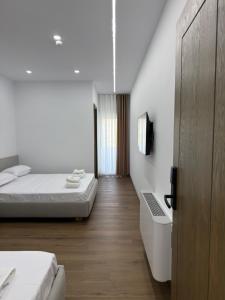 a bedroom with a bed and a tv on a wall at Petro Rooms and View in Laç