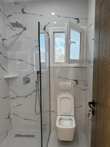 a bathroom with a toilet and a glass shower at Petro Rooms and View in Laç +18 photos