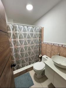 a bathroom with a toilet and a sink at Hostal Marle in Portoviejo
