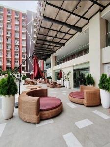 a lobby with wicker chairs and tables in a building at Dagos condo Primeworld with balcony and pool view in Mactan Island