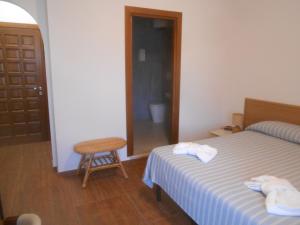 a bedroom with a bed and a chair and a door at Verde Luna B in Orbetello +20 photos