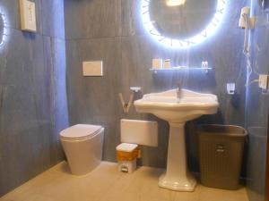 a bathroom with a sink and a toilet and a mirror at Verde Luna B in Orbetello