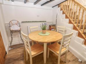 a dining room with a wooden table and chairs at Eastend Cottage in Leyburn