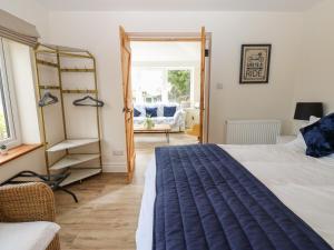 a bedroom with a bed and a chair and a window at Eastend Cottage in Leyburn
