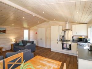 a living room with a couch a table and a kitchen at Dovestone Luxury Lodges sleeps 4- pet free in Oldham