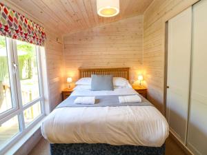 a bedroom with a large bed in a wooden room at Dovestone Luxury Lodges sleeps 4- pet free in Oldham