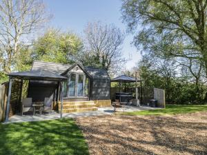 a black tiny house with a gazebo at Willow Lodge At Bridge Lake Farm & Fishery in Banbury