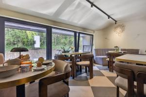 a dining room with tables and chairs and windows at Motel Reich in Velenje